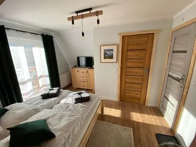 a bedroom with a bed and a large window at Willa Pod Wyciągiem in Spytkowice