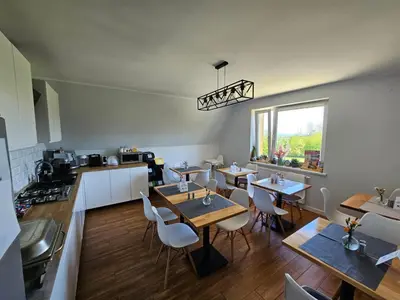 a kitchen and dining room with tables and chairs at Willa Pod Wyciągiem in Spytkowice