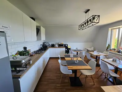 a kitchen and dining room with tables and chairs at Willa Pod Wyciągiem in Spytkowice