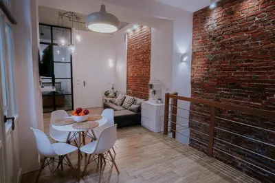 a room with a table and chairs and a brick wall at Old Town WAWEL Premium Apartment - 60m2 in Kraków