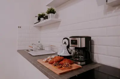 a kitchen counter with a cutting board and a coffee maker at Old Town WAWEL Premium Apartment - 60m2 in Kraków