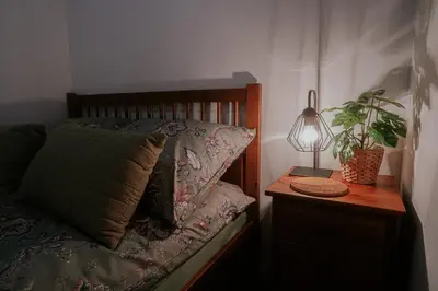 a bedroom with a bed with a table and a plant at Old Town WAWEL Premium Apartment - 60m2 in Kraków
