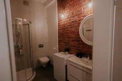 a bathroom with a sink toilet and a brick wall at Old Town WAWEL Premium Apartment - 60m2 in Kraków