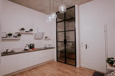a kitchen with white cabinets and a glass door at Old Town WAWEL Premium Apartment - 60m2 in Kraków
