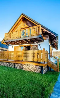 a wooden house with a porch and a fence at Wierchy Beskidu in Dobra