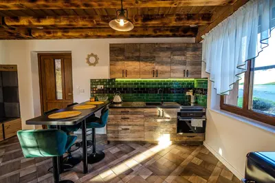a kitchen with a table and some chairs in it at Wierchy Beskidu in Dobra