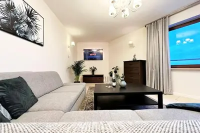 a living room with a couch and a table at Exclusive PENTHOUSE near CityCenter 120m2 +NETFLIX in Kraków