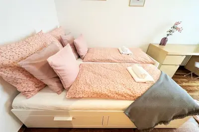 a bed with pink pillows on top of it at Exclusive PENTHOUSE near CityCenter 120m2 +NETFLIX in Kraków