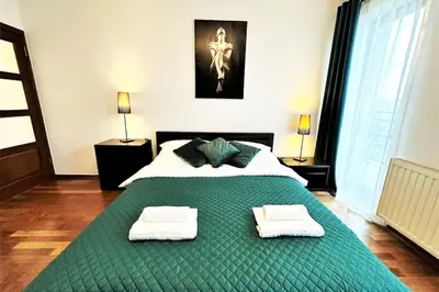 a bedroom with a large green bed with two towels on it at Exclusive PENTHOUSE near CityCenter 120m2 +NETFLIX in Kraków