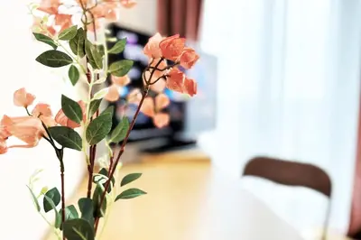 a vase with pink flowers on a table at Exclusive PENTHOUSE near CityCenter 120m2 +NETFLIX in Kraków