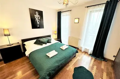 a bedroom with a large green bed with two towels on it at Exclusive PENTHOUSE near CityCenter 120m2 +NETFLIX in Kraków