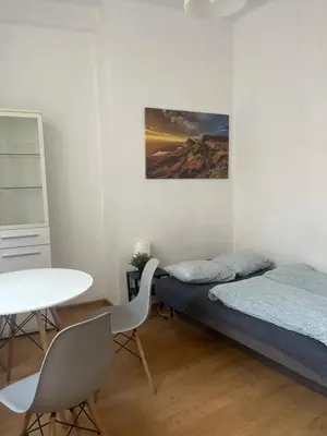 a bedroom with a bed and a desk and a table at Room in Old Town Krakow in Kraków