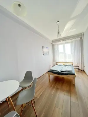 a room with a bed and a table and chairs at Room in Old Town Krakow in Kraków