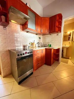 a kitchen with wooden cabinets and a stainless steel stove at Room in Old Town Krakow in Kraków