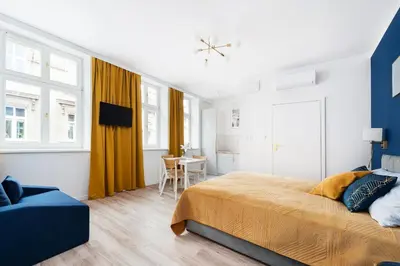 a bedroom with a large bed and a table at Rose apartment in Kraków