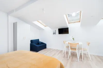 a bedroom with a bed and a table and chairs at Rose apartment in Kraków