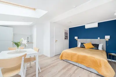 a bedroom with a king sized bed and a white table at Rose apartment in Kraków