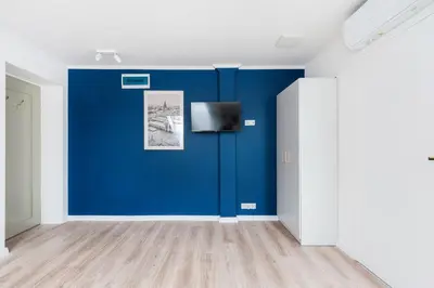 a room with a blue wall and a tv at Rose apartment in Kraków