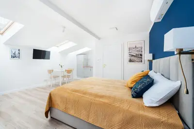 a bedroom with a large bed and a blue wall at Rose apartment in Kraków