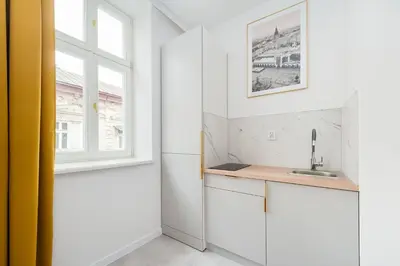 a kitchen with white cabinets and a window at Rose apartment in Kraków