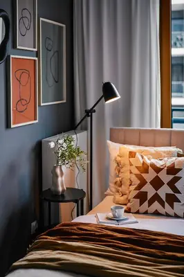 a bedroom with a bed with a table with a lamp at Przytulny Apartament Greenwall in Kraków