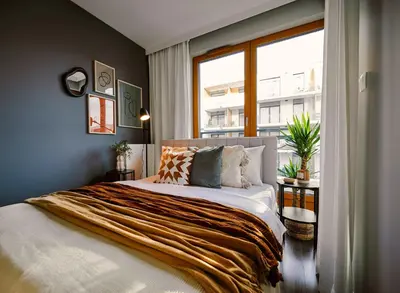 a bedroom with a large bed with a window at Przytulny Apartament Greenwall in Kraków