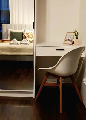 a desk and a chair next to a bed at Przytulny Apartament Greenwall in Kraków