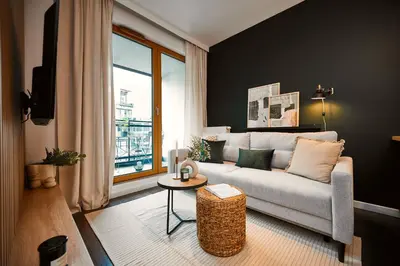 a living room with a couch and a table at Przytulny Apartament Greenwall in Kraków