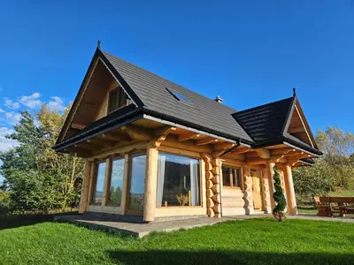 a log cabin with a black roof at beskid house in Spytkowice