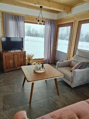 a living room with a coffee table and a tv at beskid house in Spytkowice