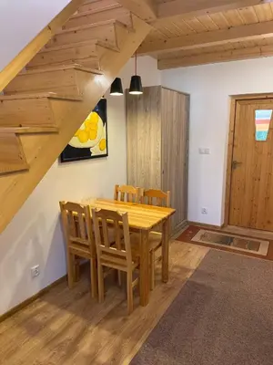 a dining room with a wooden table and chairs at U Pająka in Wieprzec