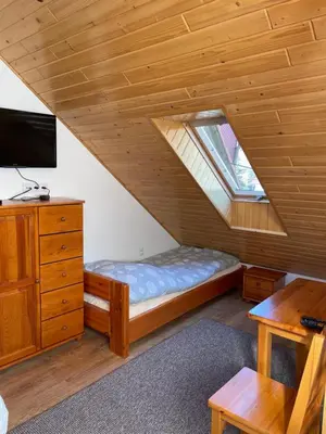 a bedroom with a bed and a tv in a attic at U Pająka in Wieprzec