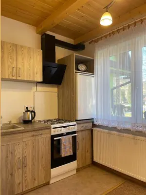 a kitchen with a stove top oven next to a window at U Pająka in Wieprzec