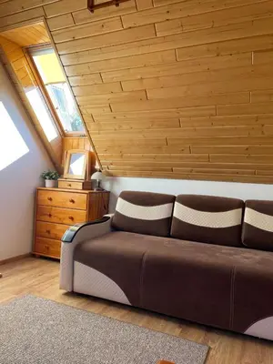 a living room with a couch and a wooden ceiling at U Pająka in Wieprzec