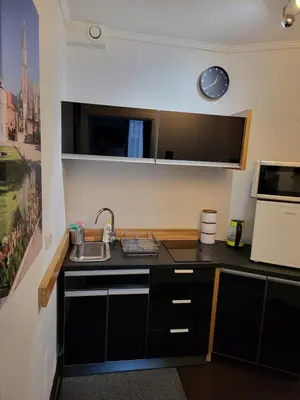 a kitchen with a sink and a clock on the wall at AMBER APARTAMENt 519 in Kraków