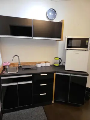a kitchen with a black counter top and a microwave at AMBER APARTAMENt 519 in Kraków