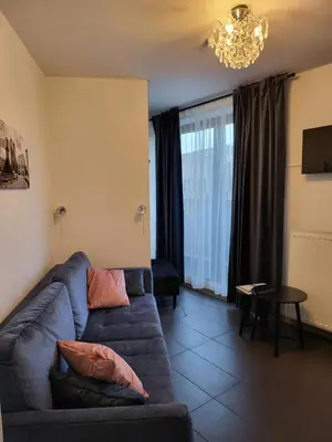 a living room with a blue couch and a table at AMBER APARTAMENt 519 in Kraków