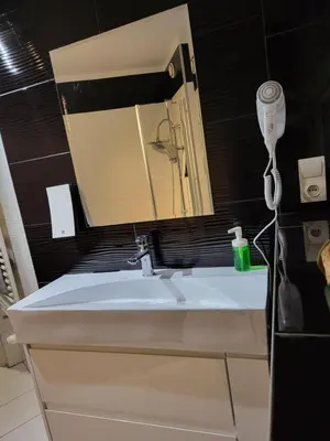 a bathroom sink with a mirror and a hair dryer at AMBER APARTAMENt 519 in Kraków
