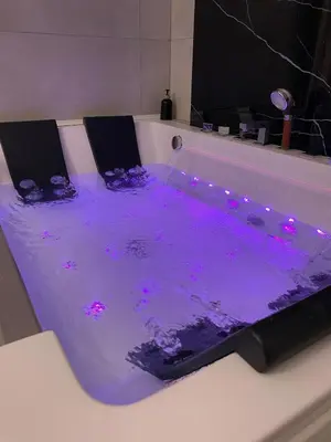 a bath tub filled with purple water in a bathroom at Apartament z jacuzzi in Kraków