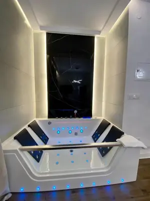 a jacuzzi tub in a room with blue lights at Apartament z jacuzzi in Kraków