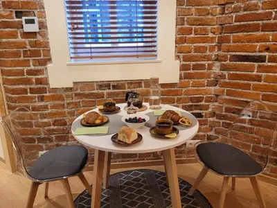 a table with food on it in front of a brick wall at Wawel Corner Apartment in Kraków