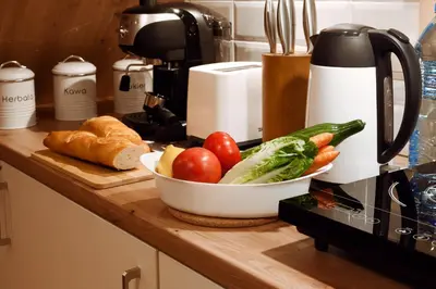 a kitchen counter with a bowl of vegetables on a counter at Wawel Corner Apartment in Kraków