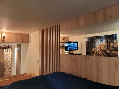a bedroom with a bed and a tv on a wall at Wawel Corner Apartment in Kraków