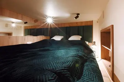 a bedroom with a large bed with a green blanket at Wawel Corner Apartment in Kraków