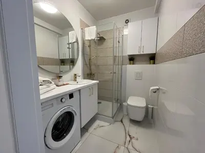 a bathroom with a washing machine and a toilet at Apartament in Bochnia