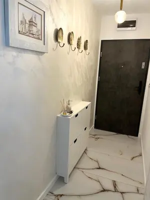 a bathroom with a white dresser and a black door at Apartament in Bochnia