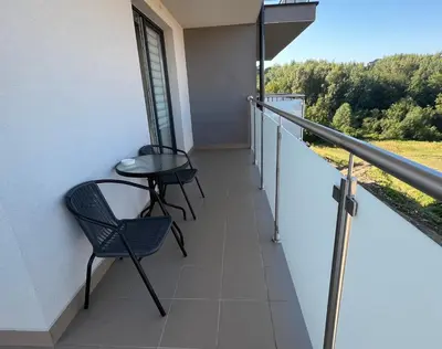 a balcony with chairs and a table on a building at Apartament in Bochnia