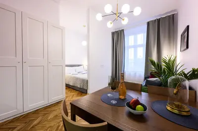 a living room with a dining room table and a bedroom at Unique Style Apartments Old Town - 25 min from the airport - by Homelike Krakow in Kraków