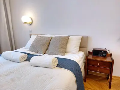 a bedroom with a bed with a clock on a night stand at Unique Style Apartments Old Town - 25 min from the airport - by Homelike Krakow in Kraków