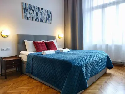 a bedroom with a bed with two red pillows at Unique Style Apartments Old Town - 25 min from the airport - by Homelike Krakow in Kraków